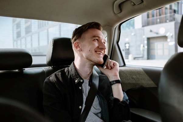 A man talking on his phone inside a taxi.