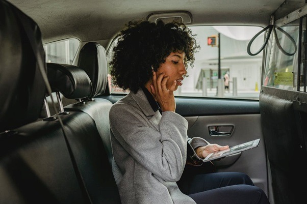 A woman working while travelling in a taxi