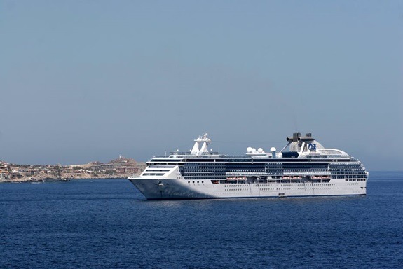 Distant shot of a large cruise ship as it carries vacation-goers.