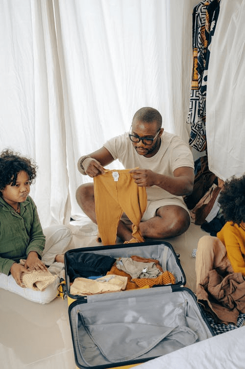  a man and his kids sitting on the floor and packing