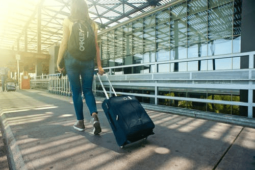 a woman carrying her luggage while at the airport