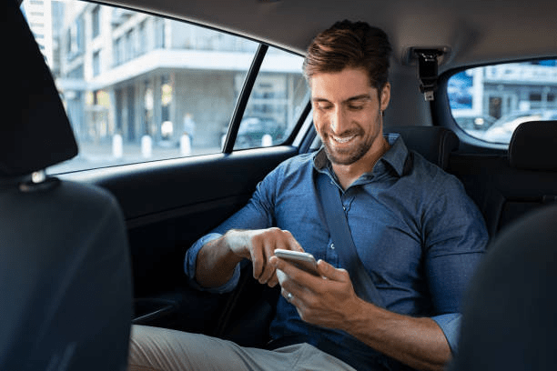 A passenger looking at his phone and smiling