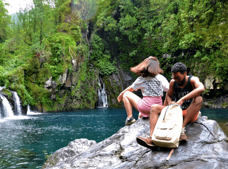 A couple sitting on a boulder.