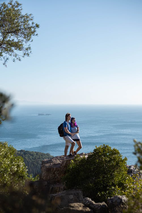 A couple standing on the cliff.