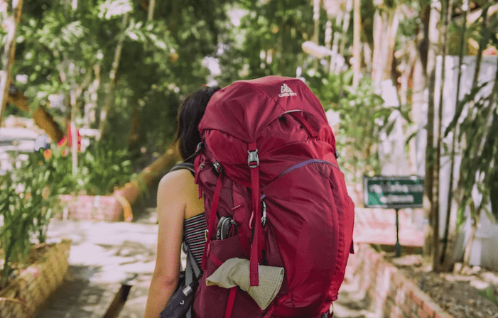 Woman carrying red backpack.
