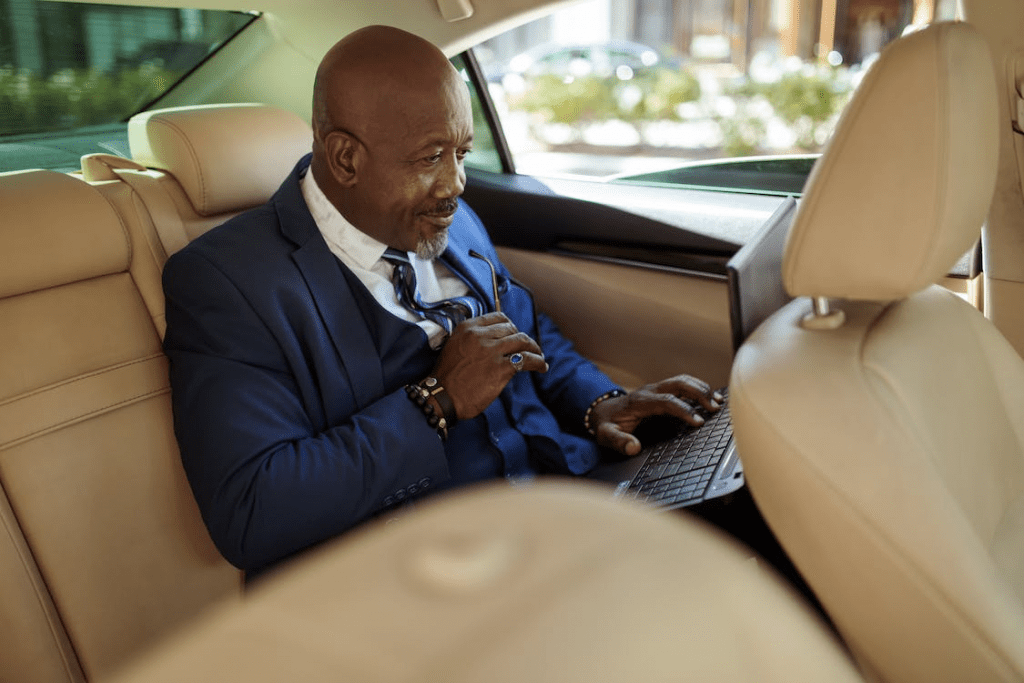  a businessman working comfortably in his premium airport taxi