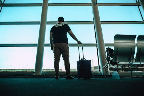 a man carrying his luggage for his flight