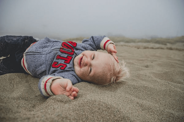 a baby playing in sand