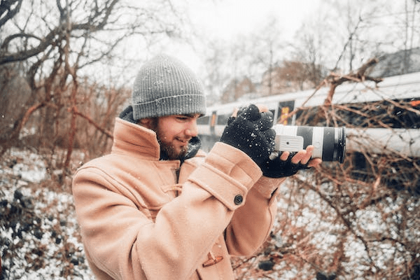 a man taking pictures in the snow