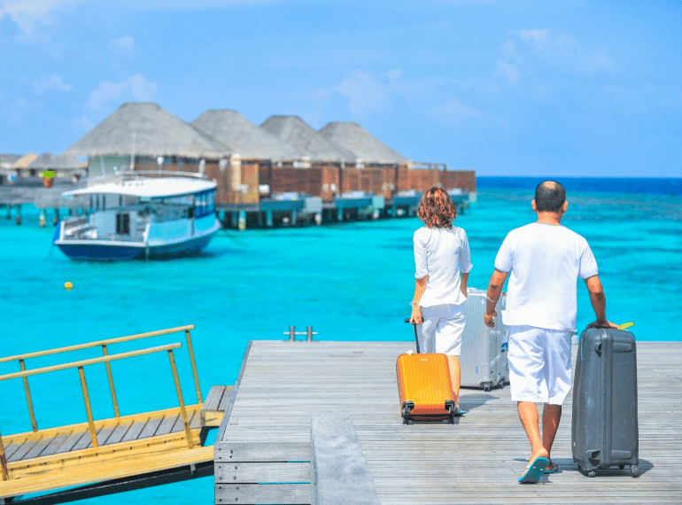 a couple strolling luggage at a cruise port