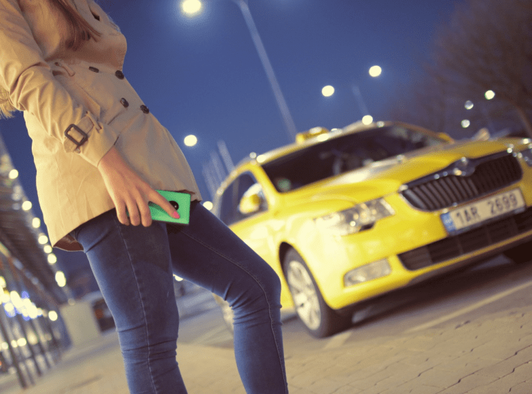 a person standing in front of a yellow taxi