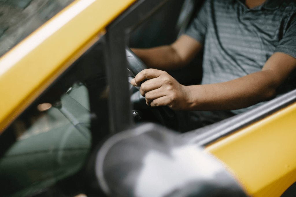 Crop casual man driving a taxi in the city