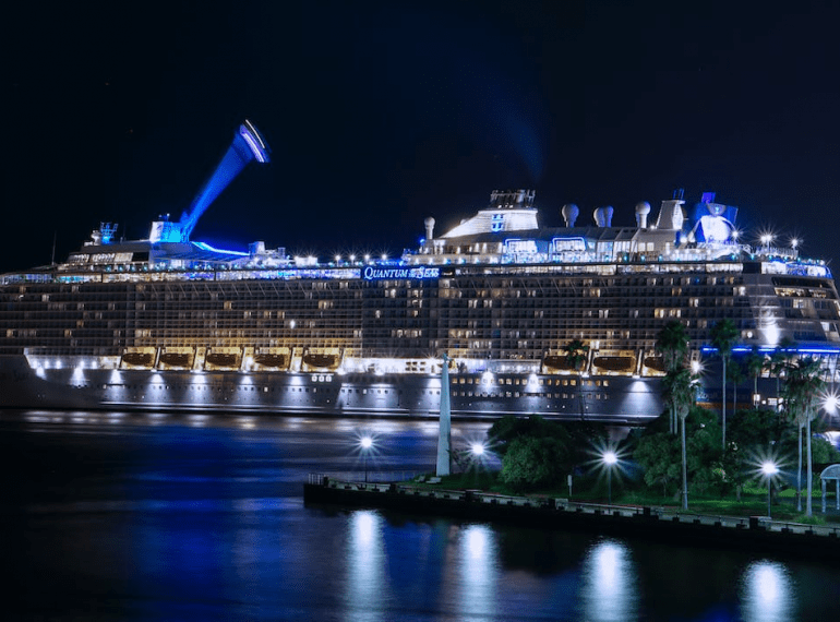 Lit up cruise ship at a port.