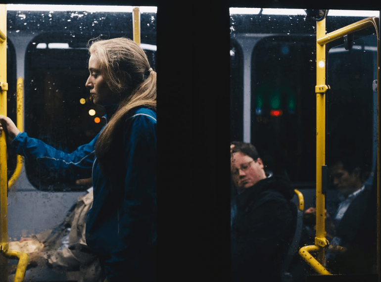 Photo of a woman standing inside a bus