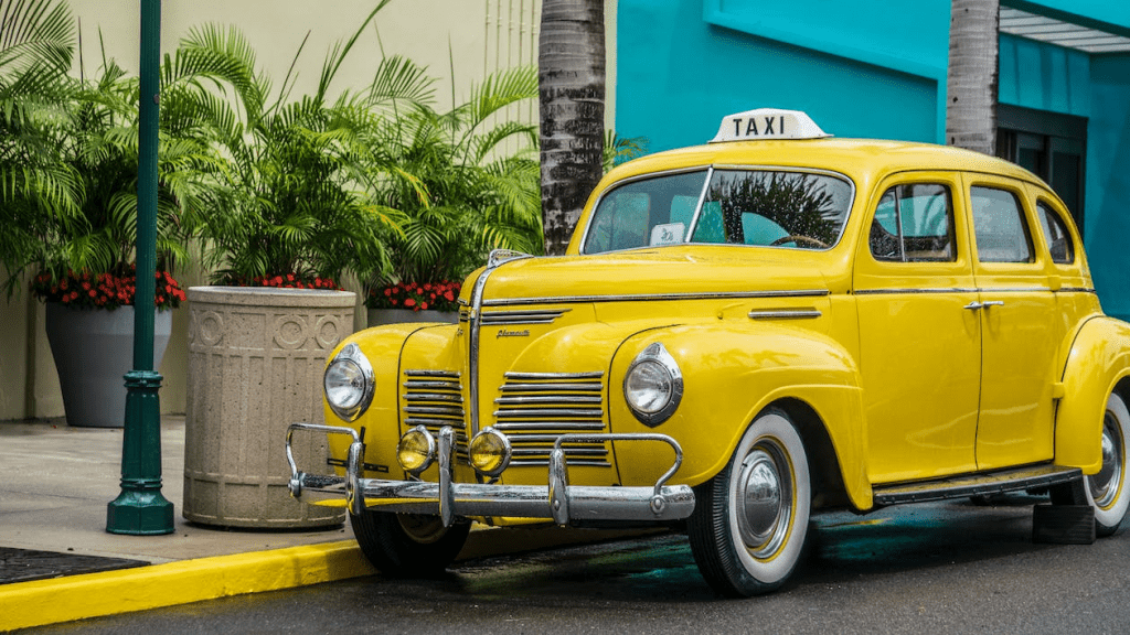 Photo of a yellow taxi parked near the sidewalk