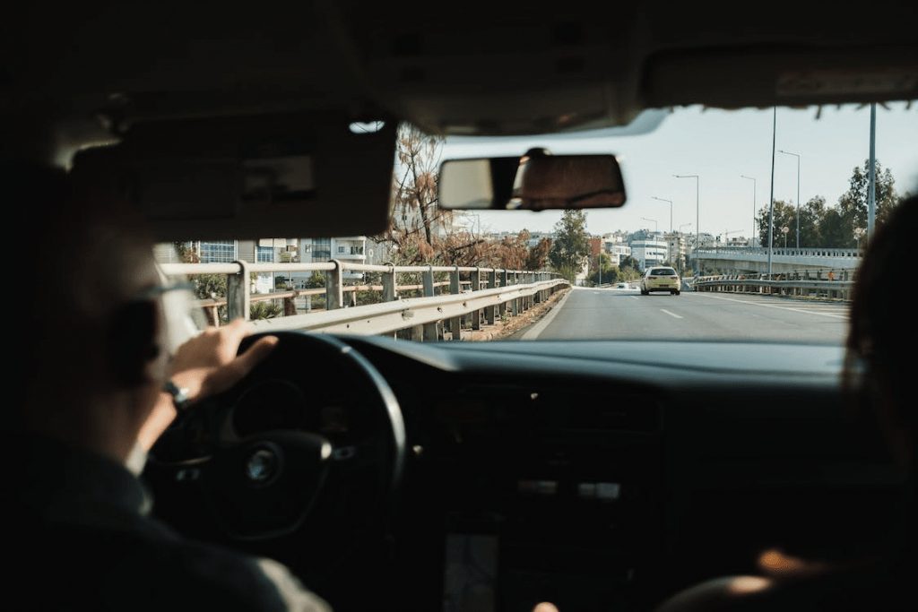 An image of a man driving a car on the street