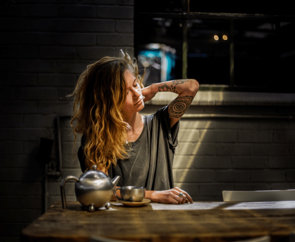 A Woman Sitting Next to a Teapot