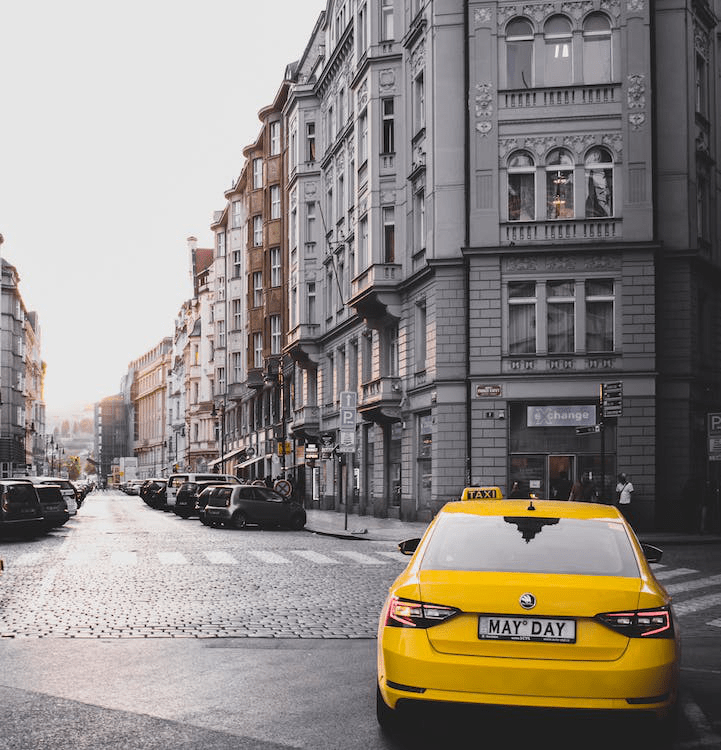 An image of a yellow vehicle near a grey building