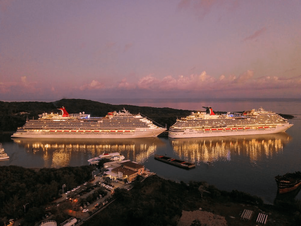 An image of two lighted cruise ships in the ocean