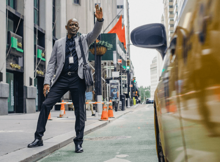 An image of a businessman catching a taxi on the side of the road
