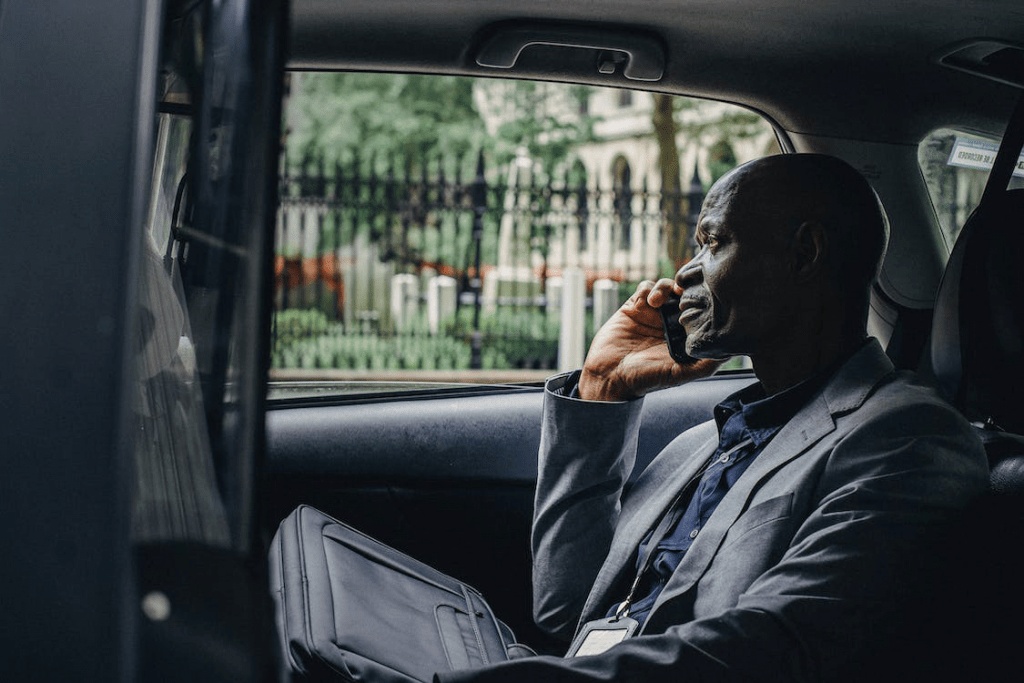 An image of a businessman speaking on the smartphone while sitting in the backseat of a car