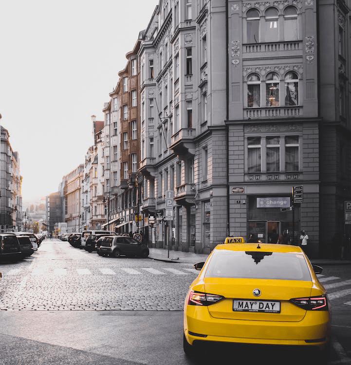 An image of a yellow vehicle near a building
