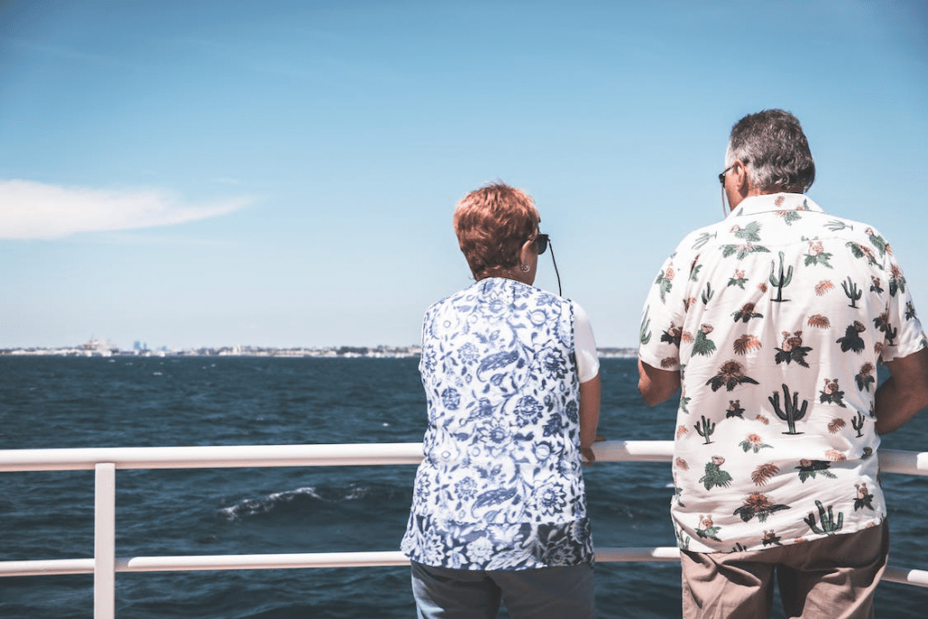 An image of an anonymous mature couple standing on a boat deck during a cruise in the sea