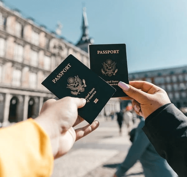 An image of two anonymous tourists showing their passports on the street on a sunny day